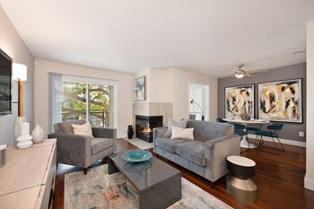 A living room with a grey couch, a coffee table, and a fireplace.